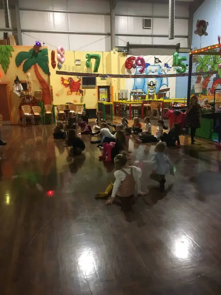 Children dancing on the floor under disco lights at a Friday night disco party