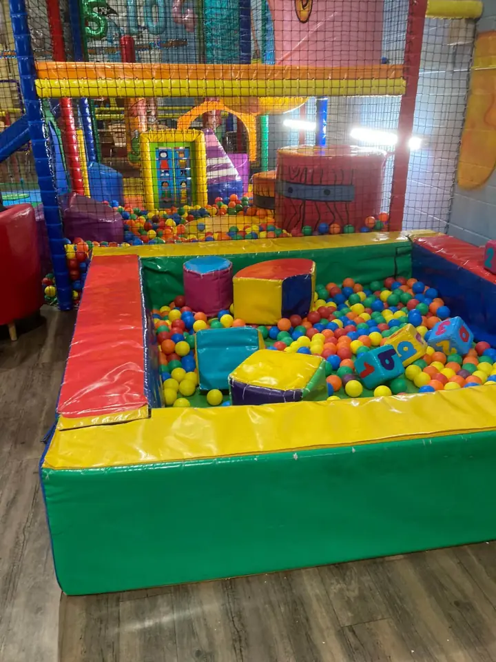A soft-sided ball pit full of coloured balls and foam number blocks